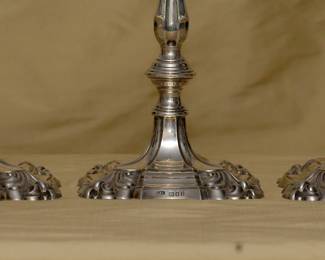 Closer view of the matched set of four antique English sterling silver candlestick holders, stamped with hallmarks for sterling silver, London, and silversmith Lionel Alfred Crichton.