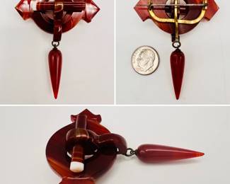 A dramatic antique Scottish brooch of carved deep red banded agate in a Celtic buckle form with attached tapering pendant bead; sterling silver pin attachment, unmarked. Stunning example of the popular Scottish "pebble jewelry" so beloved by Victorians.