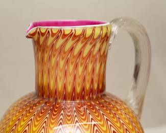 Closeup of a breathtaking antique late 19th Century Stevens & Williams Glass 'Osiris' pulled design water pitcher, cased in clear crystal over a tonal red to pale amber pulled ground with pink interior, applied clear handle