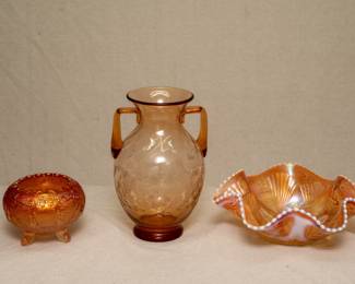 Antique Fenton Art Glass Garland Marigold carnival glass three-toed rose bowl, a vintage hand blown amber glass amphora style vase with carved floral pattern and applied handles, and an antique Dugan / Diamond carnival glass Petal and Fan peach opalescent ruffled bowl with white bead edging