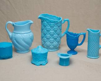 An EAPG antique Dithridge & Company blue opaline glass vanity lidded jar, a vintage EAPG light blue milk glass pitcher, a 1950s Westmoreland blue milk glass Diamond Quilt design pitcher, a rich blue art glass creamer, a Portieux Vallerysthal French art glass blue opaline milk glass pitcher, a turquoise or blue pressed glass lidded vanity jar, and an EAPG antique McKee & Bros blue opaque glass 'Plug Hat' toothpickholder or match holder, circa 1888.