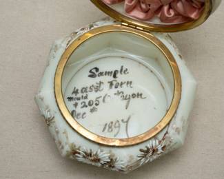 Interior view of the large 1894 sample Wavecrest glass dresser box, collars and cuffs box, 7-1/2 inches wide; octagonal form with hinged round lid, hand painted with floral sprays. Quilted pink satin padding inside, and painted on the inside with "Sample," decoration name and mould number with "1894"
