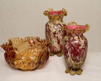 A cased glass bowl and pair of cased art glass vases, amber glass with maroon and cream marble pattern, ruffled and crimped rims, the vases with tabbed feet