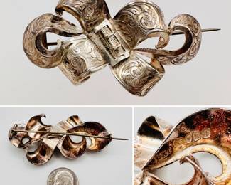 Antique dated 1847 English sterling silver brooch formed as gracefully curving ribbons with central buckle; finely engraved with foliate scrolls over a hatched ground. Hallmarks on the back show a letter date stamp for 1847 and the H&T stamp of silversmiths Hilliard & Thomason of Birmingham, England. In 1851 the firm was listed as an exhibitor at The Grand International Exhibition which was held at The Crystal Palace.