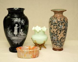 A Mary Gregory Black Amethyst art glass vase, an Akro Agate orange and white slag glass ribbed dish, a custard cased glass satin finish ruffled mouth vase with applied amber glass feet, and a late 19th Century Royal Doulton Lambeth stoneware vase by Doulton's master artist George Tinworth: Decorated with his signature "Seaweed Scroll" design, the beading to the scrolls ending in floret roundels on an amber ground