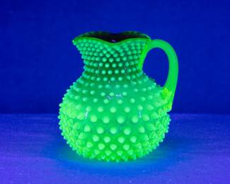 That 19th century Hobbs, Brockunier & Company dew drop or hobnail opalescent Rubina Verde uranium glass pitcher with applied clear vaseline glass handle seen under black light
