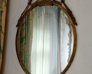 An oval urn and flowers gilt wood wall mirror