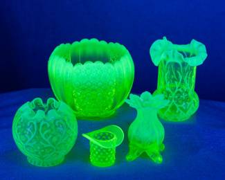 Seen under blacklight: A Fenton 'Cape Cod' daisy & button opalescent vaseline glass/uranium glass rose bowl, a Northwood ruffled Spanish Lace topaz yellow opalescent vaseline glass vase or celery glass, an antique c. 1890 Northwood Spanish Lace opal brocade vaseline opalescent rose bowl, a Fenton Topaz hobnail opalescent uranium glass toothpick holder, and a Dugan Inverted Fan & Feather 'Lady's Spittoon' form Canary color opalescent vaseline glass vase