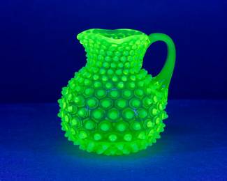 The 119th century Hobbs, Brockunier & Company dew drop or hobnail opalescent vaseline glass / uranium glass pitcher under black light.