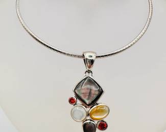 A sterling silver choker necklace with artisan crafted pendant of cabochon natural stones