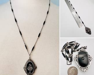 Art Deco style sterling silver pendant necklace, a silver framed black stone oval decorated with a sterling and marcasite floral basket, the back of the pendant stamped sterling and Germany.