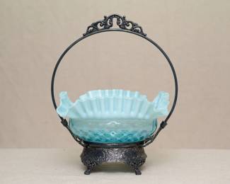 Another view of the antique 19th century blue opalescent ruffled glass brides bowl with silver plate frame, the frame showing repoussé designs and paw feet, and marked Quadruple Plate National S.W.