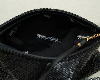 Closeup of three 1970s vintage Whiting and Davis International metallic mesh zip top clutch bags, in black, silver, and gold