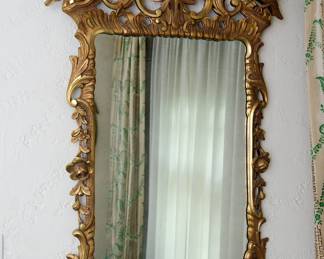 An ornate rococo style hall mirror, gilt wood with acanthus leaves, birds, floral basket crest