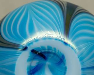 Closeup of the graceful American art glass vase by Charles Lotton (1935-2021), compressed globular form with flared rim, pulled feather design in various shades of blue; wonderful iridescence. Signed and dated 1989.