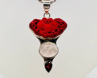 Another view of the sterling silver pendant necklace with a carved Chinese cinnabar plaque above agate/quartz cabochon stones