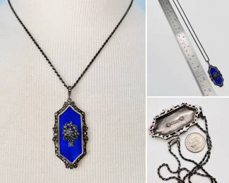 Vintage sterling silver necklace with a royal blue enameled panel pendant decorated with a silver and marcasite basket of flowers, held in a silver floral cutout frame, and suspended by a delicate rope style link chain. Marked sterling.