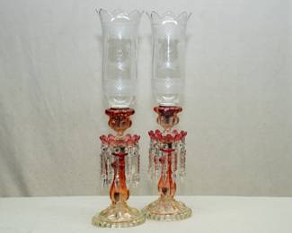 A magnificent pair of Baccarat Rose Tiente candlesticks, with hurricane shade holder at the candle cup and prisms handing from a bobéche; each with matching blown clear glass hurricane shades engraved with diamond pattern bands and beribboned floral sprays, and an Arabic inscription.