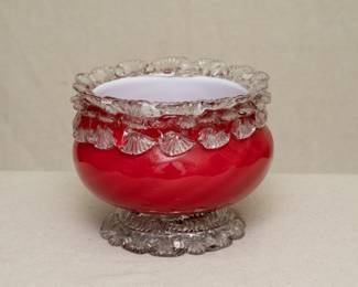 A gorgeous antique art glass bowl – late 19th century cased cranberry glass with a subtle optic swirl, a band of clear glass rigaree shell pattern at the rim and clear glass swirled shell foot. Likely a Webb Glass or Stevens & William piece.