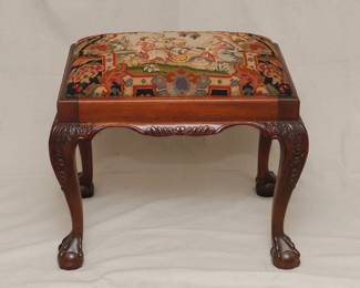A Georgian style carved wood and needlepoint covered bench, with carved apron; cabriole legs resting on ball and claw feet