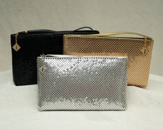 Three 1970s vintage Whiting and Davis International metallic mesh zip top clutch bags, in black, silver, and gold