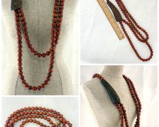 An artistic two strand large necklace of polished wooden beads and carved wooden ornament