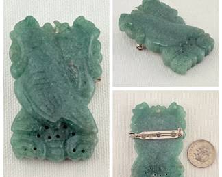 A carved green hardstone pin or brooch