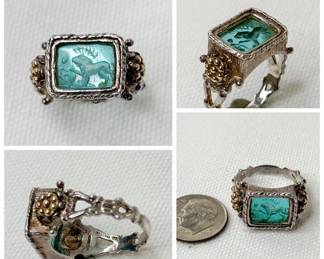 A fascinating 14k gold and sterling silver Italian made ring with intaglio carved blue glass showing a standing lion, paw raised, and a human figure kneeling before the lion's outstretched paw. Could this be a scene of Androcles removing the thorn from the lion's paw?