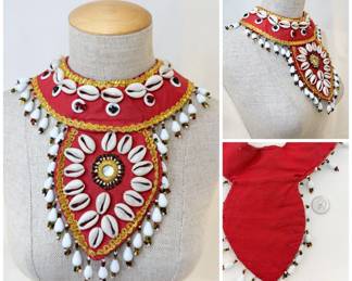 Beautiful handmade folk art jewelry with cowrie shells and beads on a bib style red fabric base