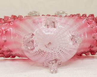 Another view of the truly amazing antique art glass basket, 11.5 tall, with clear glass twisted rope handles attached to the cranberry-to-clear basket that also has a pulled feather pattern in it; a band of hobnail texture below the double crimped rim and resting atop four clear glass feet. Likely a Stourbridge / Stevens & William piece.