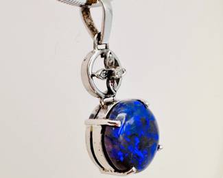 Closeup of the 14k white gold and dramatic cabochon black opal pendant necklace