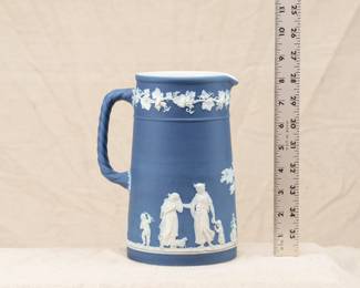A Wedgewood blue dip jasperware pitcher with rope handle, decorated with in white relief with classical figures beneath a band of fruiting grape vines