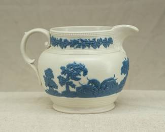 Another view of the antique circa 1810 Chetham and Woolley Hunt Jug, feldspathic stoneware cream color body with applied blue relief of a fox hunting scene, smear glazed. Chetham & Woolley was an earthenware manufactory in Staffordshire, England established by James Chetham & Richard Woolley around 1795.