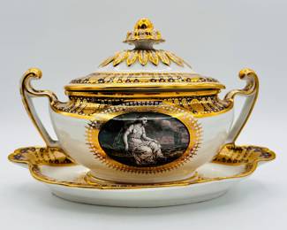 A rare Worcester Porcelain (Flight) lidded sauce tureen with underplate from the ‘Hope service’ circa 1792, signed with blue crowned script Flight and open crescent marks, painted by John Pennington. The celebrated 'Hope' service was commissioned by the Duke of Clarence and St Andrews (later King William IV), in January 1790, and was completed just over a year later. The Neo-Classical service consists of a soft-paste porcelain base, with a bold blue underglaze lobed border, with gilt patterae, and gilt arched panels and stars. The centre cartouche artwork features the Greek mythological Hope, painted in monochrome using the French-inspired grisaille style. Across the set, Hope is depicted in a variety of poses with an anchor, and often with a ship in the distance. The Duke of Clarence was affectionately nicknamed the ‘Sailor King’ when he came to the throne, as he had joined the Royal Navy at the young age of 13 as a midshipman.