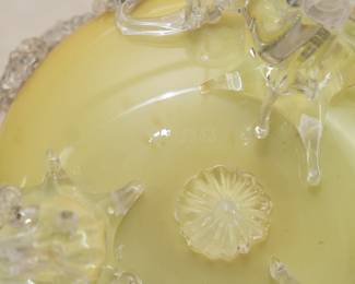 Closeup of the 19th century cased art glass bowl on three applied clear glass feet and decorated with clear rigaree