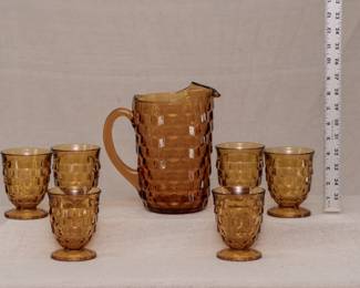 Quite mid-century modern style amber glass pitcher and tumblers set. Attributed to Colony from their Whitehall Amber line, the set includes a serving pitcher with ice lip and six footed tumblers