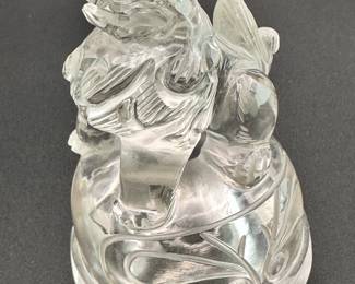 Closeup of the lid of the Chinese carved rock crystal censer and cover, early 20th century, of compressed globular form, resting on three short paw-shaped feet, the lid surmounted with a seated mythical beast, shoulders are flanked by mythical beast mask handles. Both the lid and body are carved with taotie mask designs.
