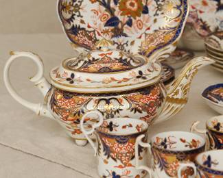 Closeup of the group of 18th and 19th century Crown Derby Imari 'Kings' pattern porcelain, including tea cups and coffee cups with saucers, teapot, coffee cups, footed large serving platter/lazy susan, lidded sauceboat with tray, creamer, sugar, serving bowls and platters, and a footed compote or fruit stand