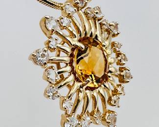 Closeup of the 14k yellow gold starburst form diamond and citrine pendant necklace