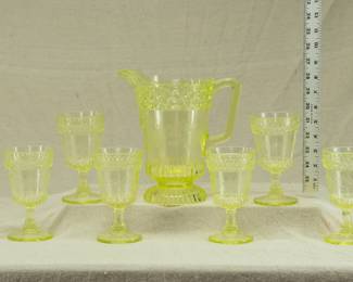 A U.S. Glass Co. Wildflower pattern vaseline / uranium glass seven-piece water or lemonade set comprising a water pitcher and six tumblers, fourth quarter 19th century.