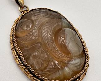 Closeup of the carved stone pendant on chain necklace