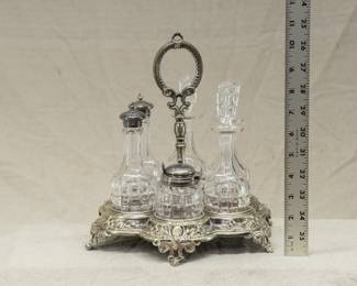 An English silver plated cruet stand with three cut glass cruets with original stoppers, matching salt and pepper shakers, and mustard pot. 