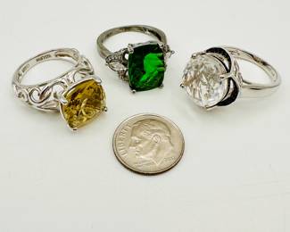 A trio of sterling silver rings with faceted colored stones