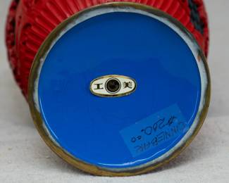 (Please note this photo includes old price tag from when our client originally purchased the pieces, and does not reflect the current sale price.) Closeup view of the two vintage Chinese large cinnabar lacquer vases, beautifully carved with floral motif and scrolling design on a black geometric ground, original maker's label to underside of one of the vases.