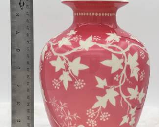 A beautiful cameo carved art glass vase, cased glass of warm rosy pink over white and carved with trailing ivy vines