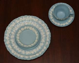 A closeup of the group of Wedgwood Embossed Queensware white vine on blue shell edge china, service for eight, also includes coffee pot, tea pot, creamer and sugar