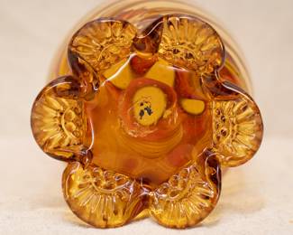 Closeup of the large 11.5 inch hand blown amberina glass vase with swirled optic ribbed body, ruffled rim, atop applied amber glass tabbed feet 