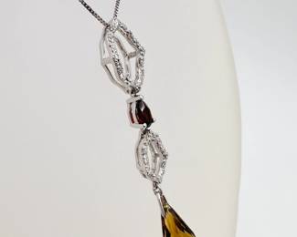 Closeup of the 18k white gold pendant featuring diamonds a lovely citrine briolette cut drop an 18k white gold chain necklace