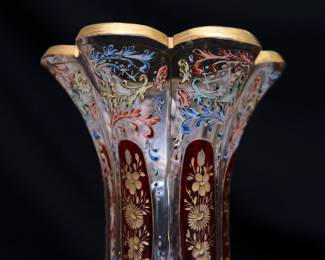 Closeup of the stunning and large antique Bohemian art glass vase (Moser? Harrach?) intricately painted overall with acanthus leaf scrolls in polychrome enamel, with cranberry glass panels containing wheel carved gilded flowers, and gold gilding at the flared rim.