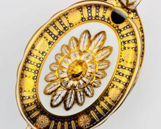 A top view of the rare Worcester Porcelain (Flight) lidded sauce tureen with underplate from the ‘Hope service’ circa 1792, signed with blue crowned script Flight and open crescent marks, painted by John Pennington. The celebrated 'Hope' service was commissioned by the Duke of Clarence and St Andrews (later King William IV), in January 1790, and was completed just over a year later. The Neo-Classical service consists of a soft-paste porcelain base, with a bold blue underglaze lobed border, with gilt patterae, and gilt arched panels and stars. The centre cartouche artwork features the Greek mythological Hope, painted in monochrome using the French-inspired grisaille style. Across the set, Hope is depicted in a variety of poses with an anchor, and often with a ship in the distance.